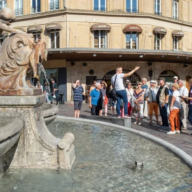 Groupe de touristes en visite guidée près de la fontaine Gonzague à Charleville-Mézières