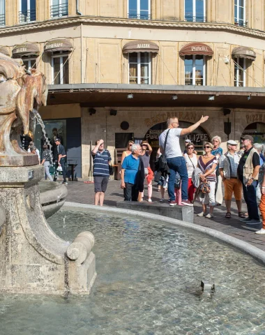 Groupe de touristes en visite guidée près de la fontaine Gonzague à Charleville-Mézières